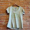 Front of Ouray women's scoop neck, short sleeve tee in the colorway Pastel Lilac (light green). The logo is printed in an avocado green color depicting mountains above the text "Montana, The Last Best Place."
