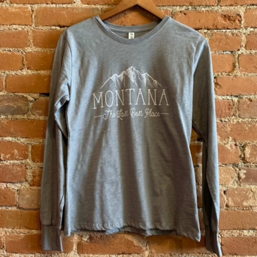 Front of women's long sleeve crew neck shirt in the colorway Medium Grey Heather (grey). "Montana, The Last Best Place." is printed in white ink with white mountains.